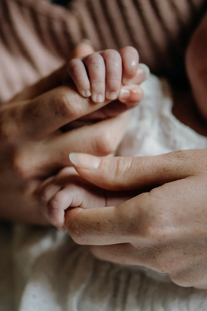 Mano de un bebé sujetando el dedo de su madre